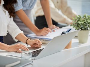 Cropped image of business ladies reading e-mails on laptop screen